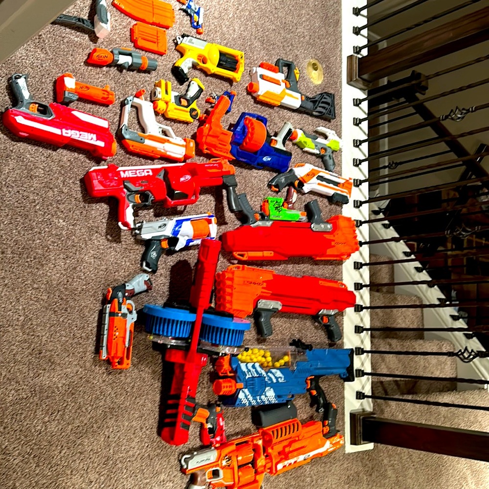 Variety of 21 nerf guns ranging sizes and make with some attachments and mags